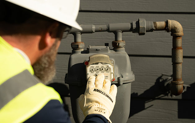 A gas worker looks at a gas meter